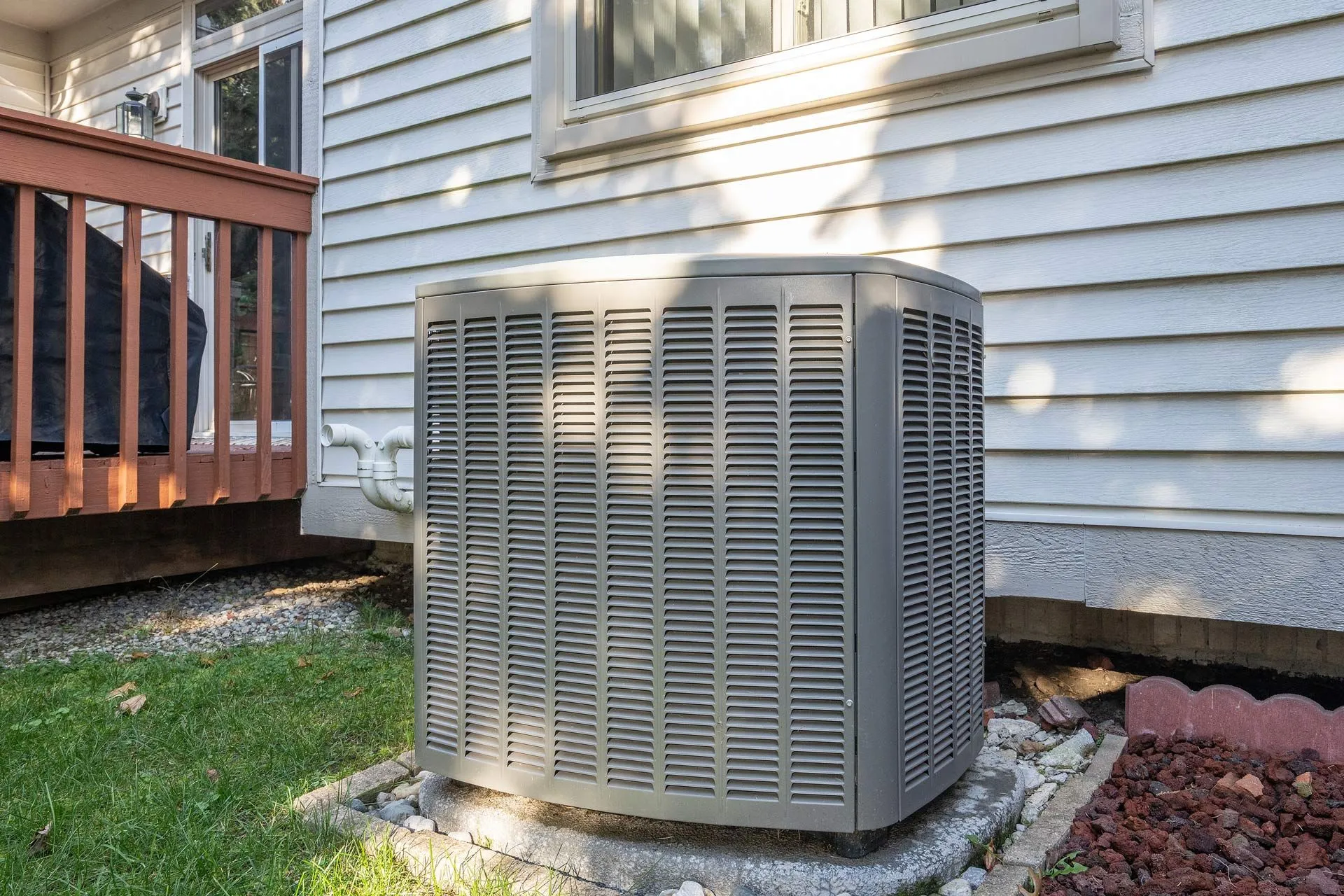 An air conditioner is sitting on the side of a house. Residential air conditioning service