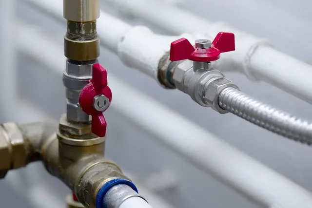 A close up of a water pipe with a red valve. Gas piping service Gresham, OR.